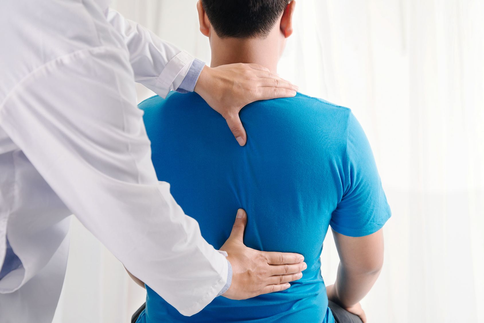 Therapist assessing a patient's back