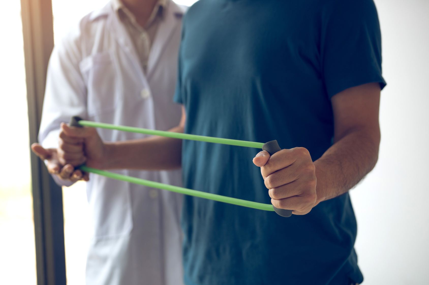 Patient doing a resistance band exercise with a therapist